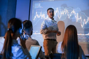 Leader presents Trading Lessons Learned to team in office.