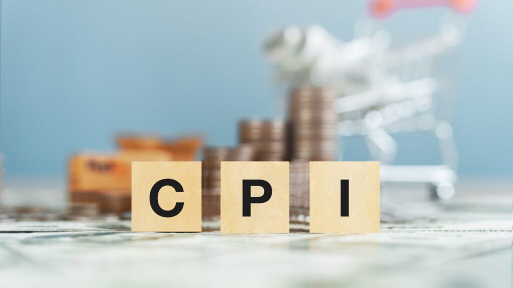 Wooden block with CPI text and shopping cart illustrating Consumer Price Index and Interest Rates connection.