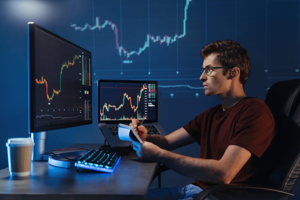 Person analyzing candlestick chart on screen using AI trading strategy