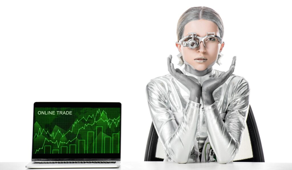 Silver robot at desk using laptop for Artificial Intelligence in Forex Trading on white background.