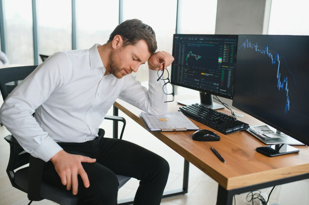 Forex trader alone at desk, showing loneliness in trading.