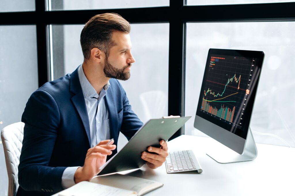 Investor reviewing forex charts to find the best forex managed account provider.