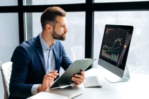Investor reviewing forex charts to find the best forex managed account provider.