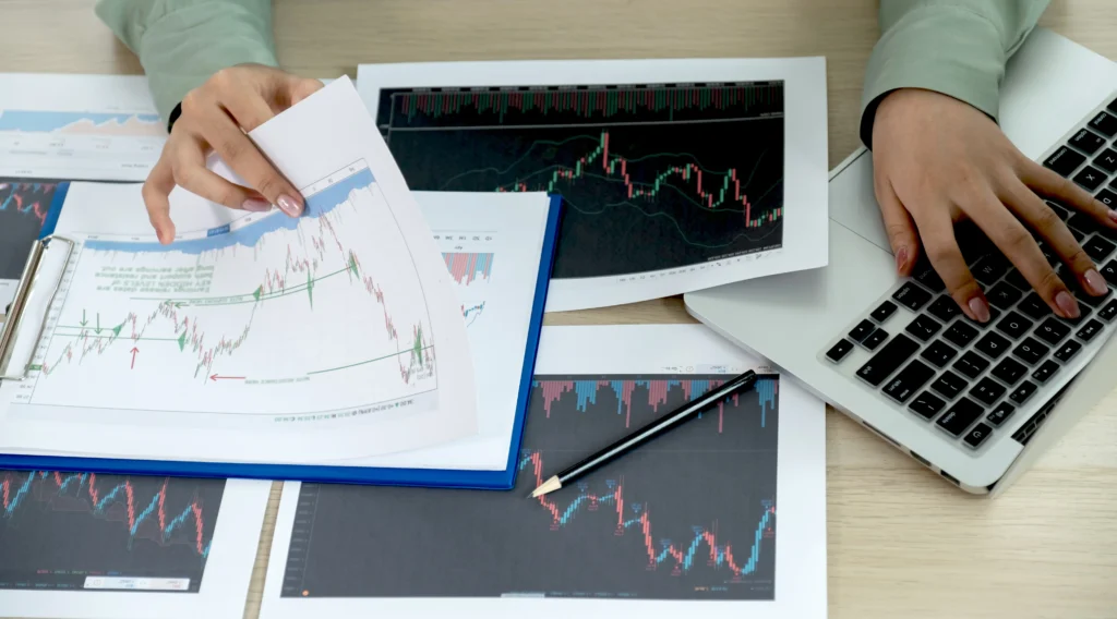 Businesswoman hand holding pencil analyzing stock graph, Retail vs Institutional Forex Trading