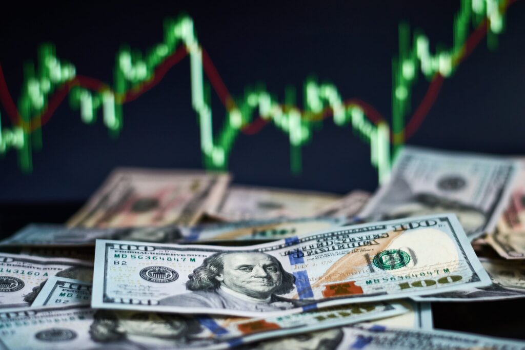 US dollar bills placed over a forex trading chart showing exchange rate fluctuations and financial risk indicators.