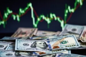 US dollar bills placed over a forex trading chart showing exchange rate fluctuations and financial risk indicators.