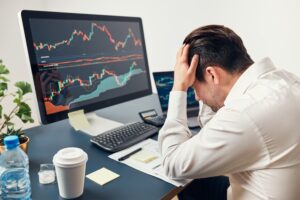 Worried investor looking at trading charts after facing forex managed account mistakes.