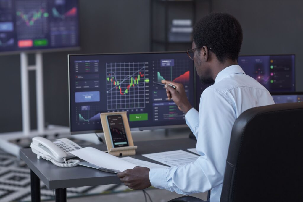 Focused trader facing the Forex Challenge while analyzing currency charts on a computer.