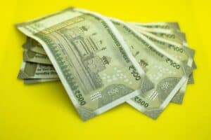 Indian 500 rupee notes on yellow background representing Rupee Rally 2025 and currency appreciation