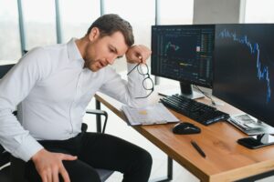 Trader at computer limiting beliefs in trading in 2025