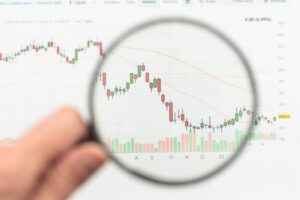 Close-up of best candlestick patterns on a trading chart under magnifying glass.