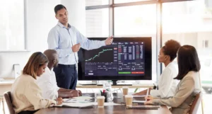 Business team reviewing Trading the Trend with Strong Weak Analysis on a forex chart during a strategy presentation.