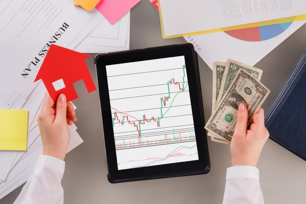 Tablet with trading chart, person holding cash and house figure, concept of Can Forex Trading Really Make You Rich