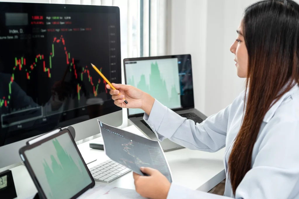 Businesswoman analyzing a downtrend chart pattern on computer.