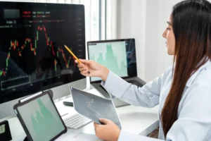 Businesswoman analyzing a downtrend chart pattern on computer.