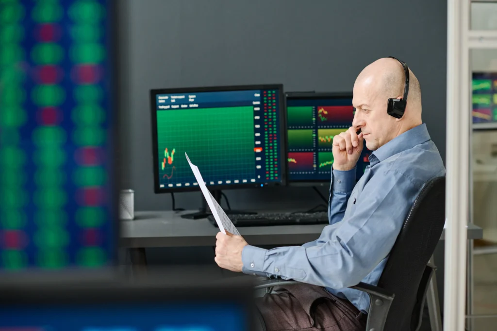Trader reviewing market charts and documents for same day expiration options strategies.