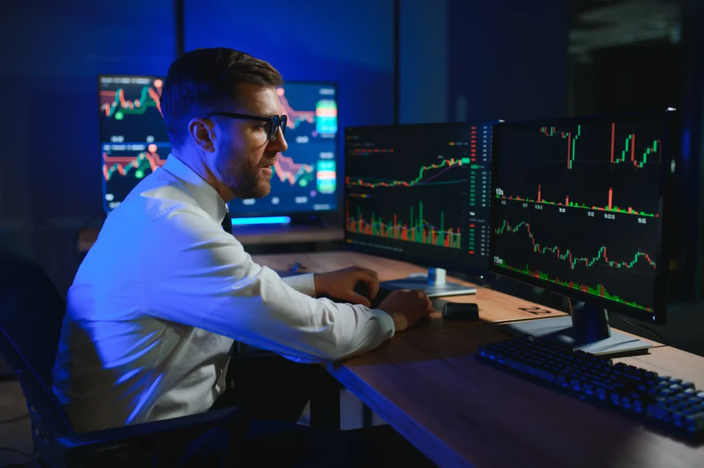 Professional trader analyzing charts on computer screens for Automated Trading vs. Copy Trading strategies.