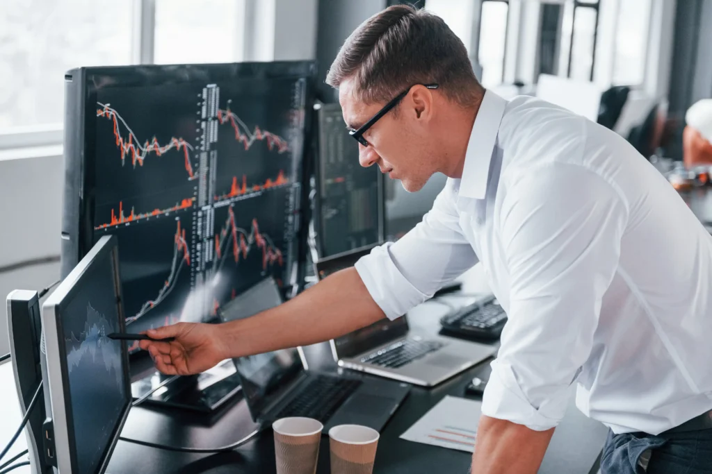 Trader studies Cup and Handle Pattern on trading screens for market breakout signals.