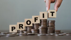 Best leverage ratio concept shown with blocks spelling profit on stacked coins.
