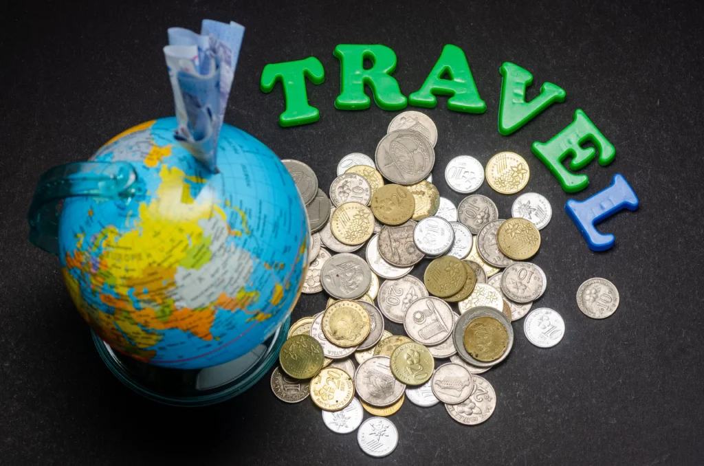 Globe with foreign coins and travel letters symbolizing forex trading and international travel