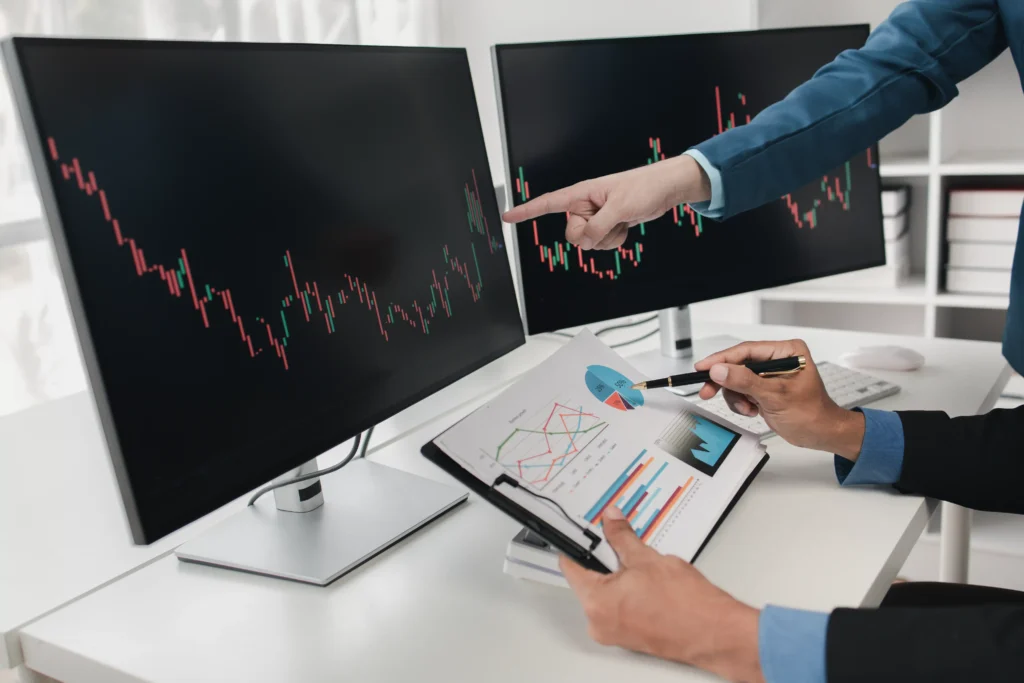 Pivot Points Trading Strategy with traders reviewing candlestick charts and financial graphs on computer screens.