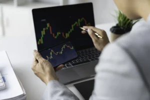 Elliott Wave Theory trading analysis on laptop and smartphone candlestick charts.