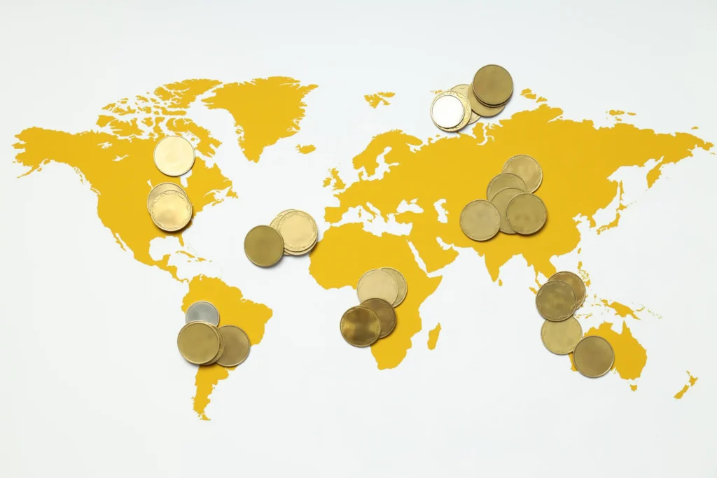 World map with coins symbolizing weakest currencies in the world 2025 and lowest exchange rates