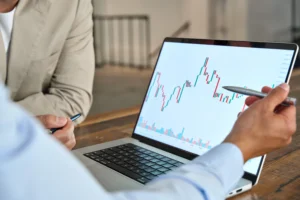 Breakout vs Breakdown pattern chart analysis on laptop screen during market discussion.