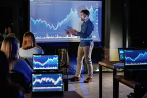 Professional trader showing market charts during training session.