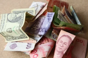 Mixed Asian currencies including Singapore dollar, Japanese yen, Chinese yuan, Thai baht, and US dollar notes representing the strongest currencies in Asia 2025.