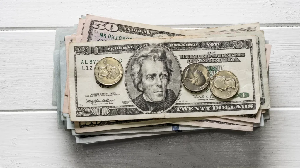 Stack of US dollar bills and coins showing forex trading and currency exchange.