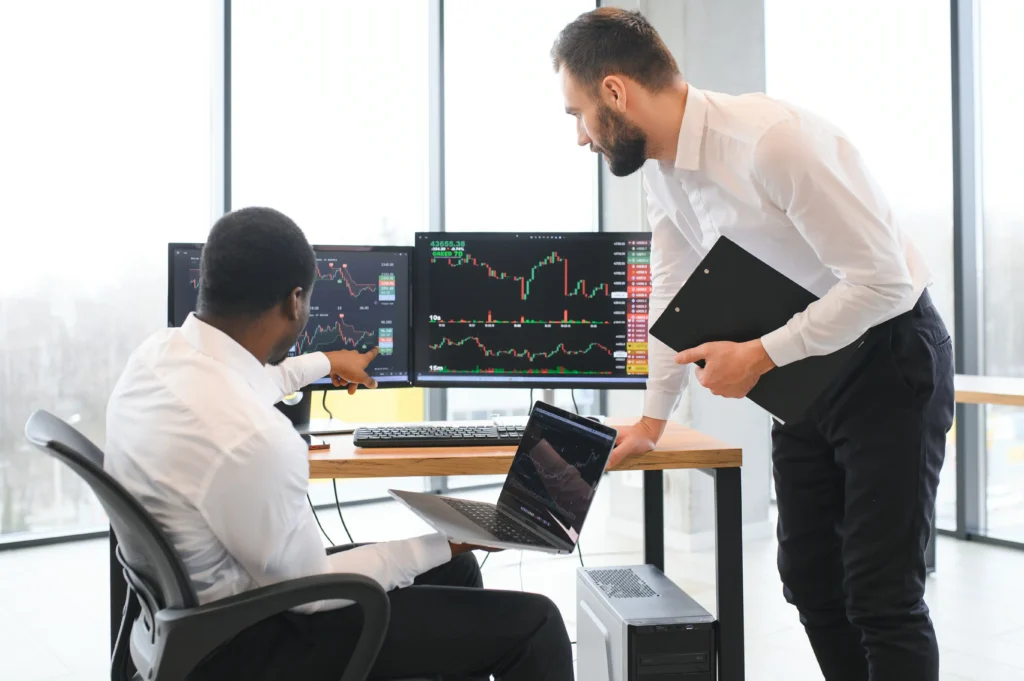 Traders at computers demonstrating the advantages of proprietary trading in a professional environment