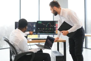 Traders at computers demonstrating the advantages of proprietary trading in a professional environment