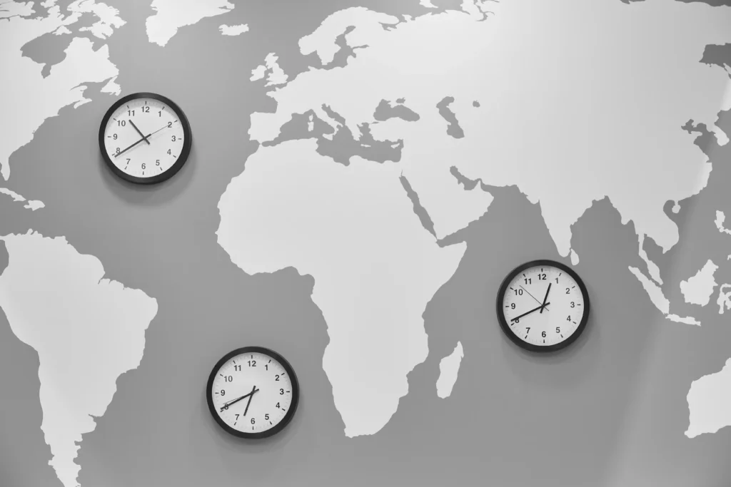 World map with clocks showing time zones, symbolizing global markets and time zones in trading.
