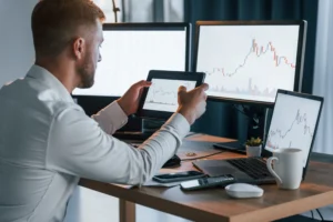 Trader analyzing candlestick charts on multiple screens to identify the most reliable trading patterns.