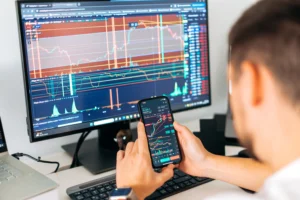 Trader analyzing real-time volume scalping charts on desktop and mobile.