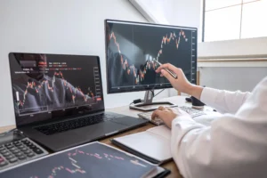 A trader analyzing candlestick charts on multiple monitors, identifying pullbacks and trend reversals in the forex market.