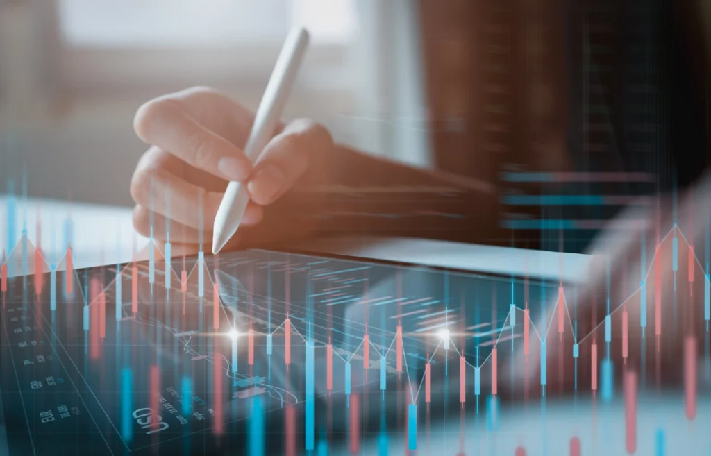 A trader analyzing digital charts on a tablet, symbolizing Mid-Year Market Update 2025 and global financial trends.