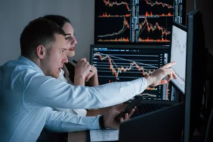 Professional traders comparing Spot Trading vs Margin Trading on multiple monitors showing live forex and stock charts.
