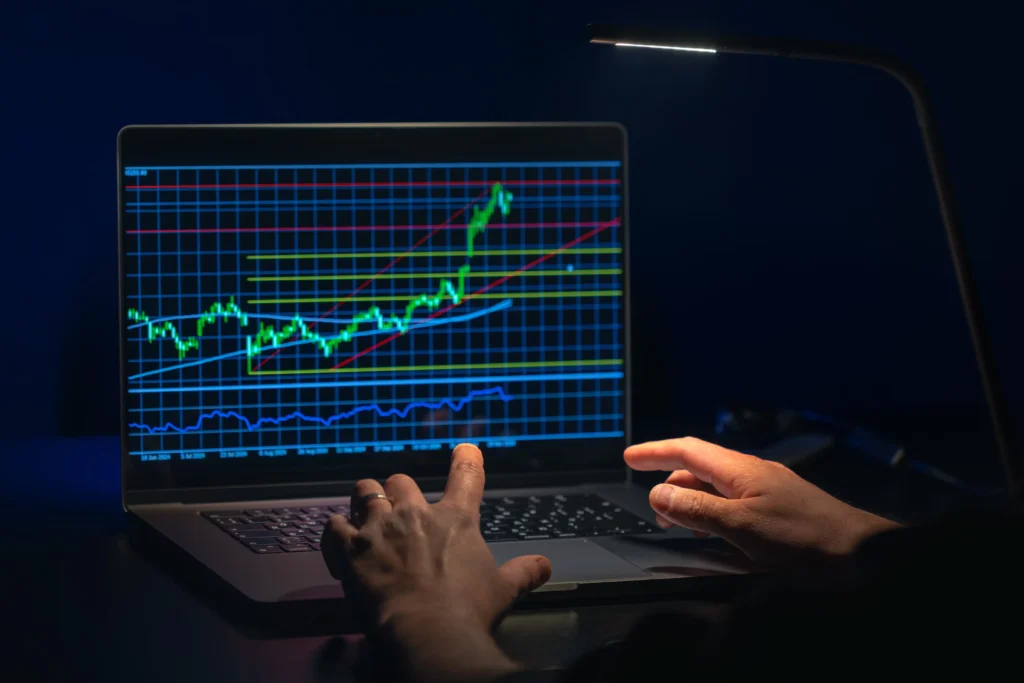Trader analyzing Forex chart with trend lines and reversal signals on laptop screen.