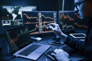 Forex trader comparing Scalping vs Day Trading Capital 2025 with live charts on laptop and monitors.