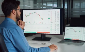 Trader analyzing forex charts and setting a limit order on dual monitors in a modern office environment.