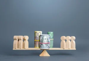 Wooden figures and rolled banknotes on balance scale symbolizing ETP vs ETF comparison.