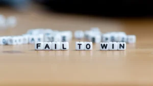 Fail to Win text on white letter cubes symbolizing how traders Turn Trading Losses Into Learning Wins through experience and reflection.