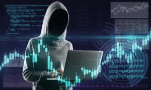 Anonymous person in a hoodie using a laptop with glowing forex charts, representing online forex scams and digital trading fraud.