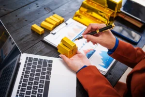 Investor analyzing gold bars with charts and laptop, comparing gold performance with multi-asset fund data for portfolio planning.
