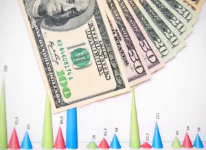 Currency pair correlations concept with US dollar bills placed over financial market charts.