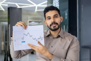 A forex analyst holding a printed chart and explaining market swings using the Zig Zag Indicator in Forex during a trading session.
