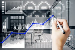 Hand drawing a blue trading line with data charts and indicators showing volume-based market analysis in a modern office background.