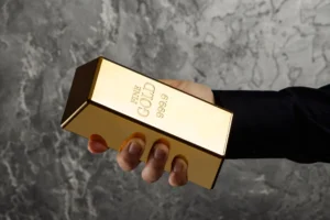 A person holding a 999.9 fine gold bar symbolizing global gold value, investment security, and purity in 2025 markets.